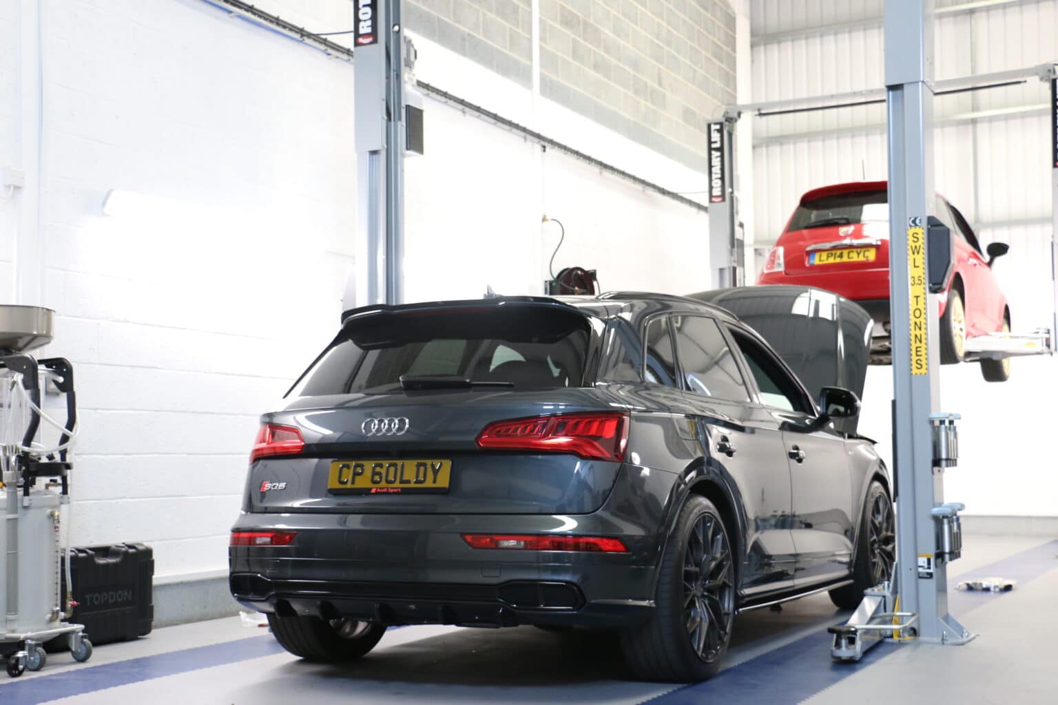 Audi SQ5 and a Fiat 500 on the ramps in the JF Automotive service workshop in Maidstone